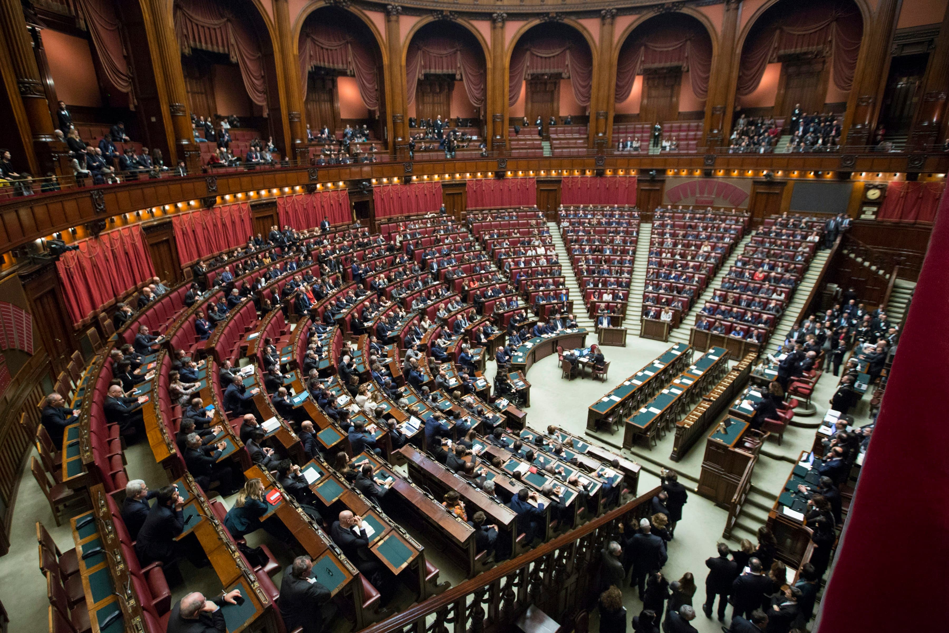 Lawmakers seated in a wood-panelled parliamentary chamber during a session