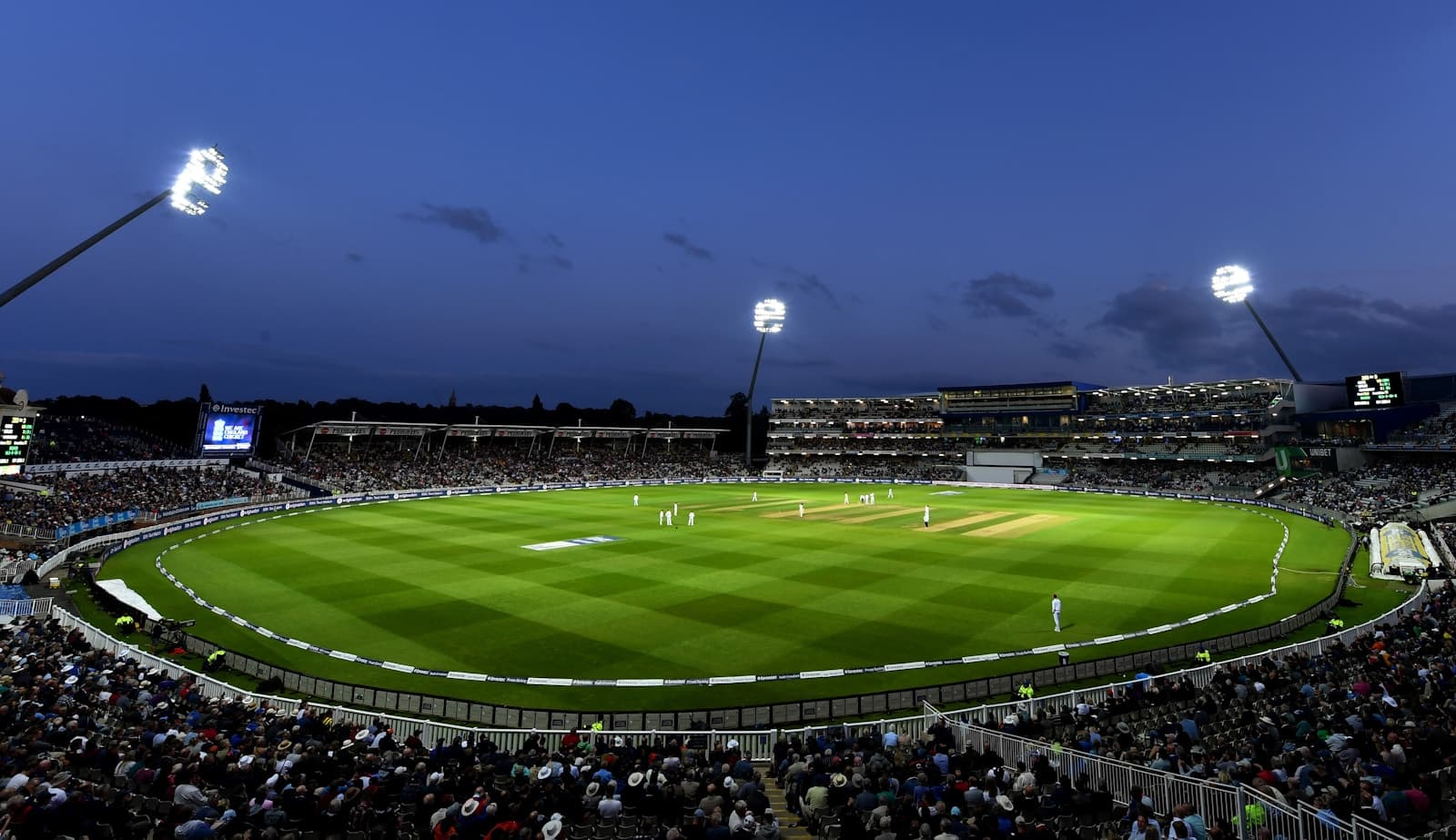 Floodlit cricket Test match in a packed stadium at dusk