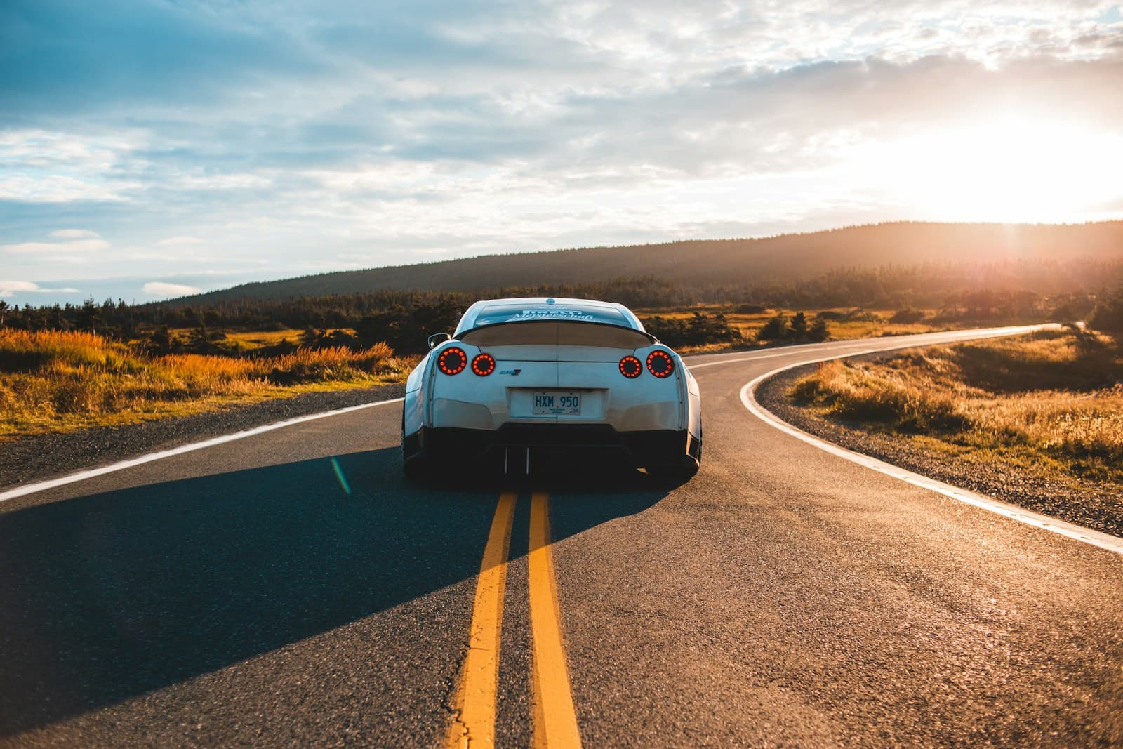 A car on an open road at dusk, when headlamp glare from oncoming traffic is a daily hazard for Indian riders